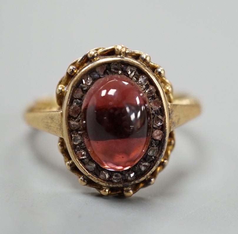 A Victorian style yellow metal cabochon garnet and rose cut diamond set oval cluster ring, size N/O, gross weight 5.2 grams.